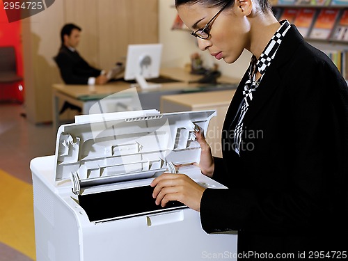 Image of businesswoman using copy machine