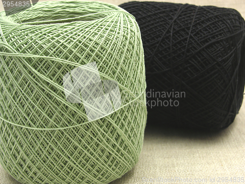 Image of Two balls of wool  lying and standing on a beige background