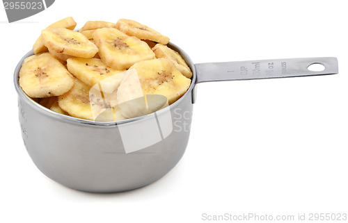 Image of Dried banana chips in a cup measure