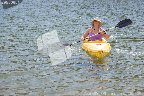 Image of Woman Kayaking on Beautiful Mountain Lake.