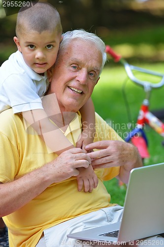 Image of grandfather and child using laptop