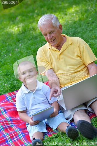 Image of grandfather and child using laptop