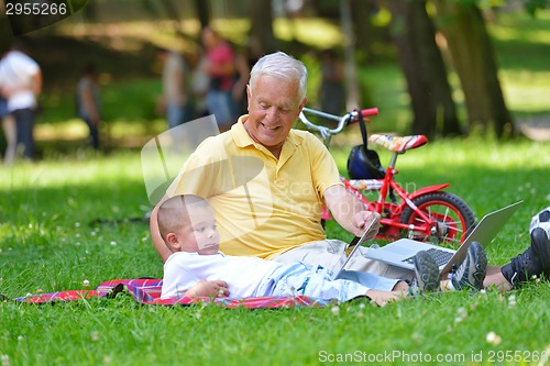 Image of grandfather and child using laptop