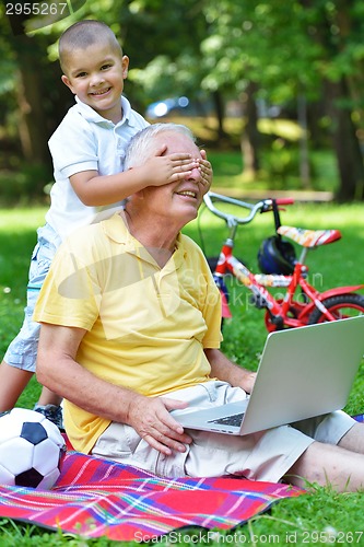 Image of grandfather and child using laptop