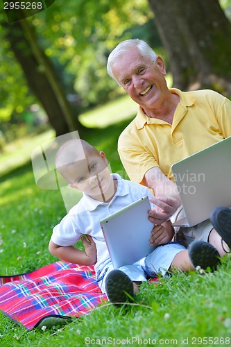 Image of grandfather and child using laptop