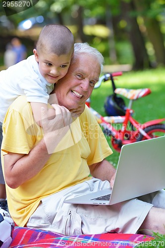 Image of grandfather and child using laptop