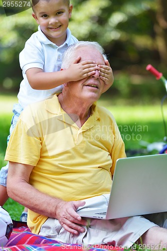 Image of grandfather and child using laptop