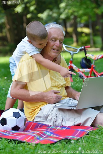 Image of grandfather and child using laptop