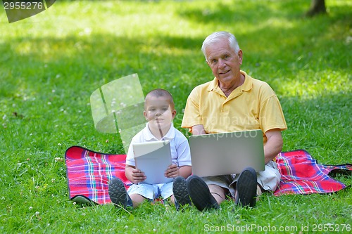 Image of grandfather and child using laptop