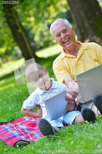 Image of grandfather and child using laptop