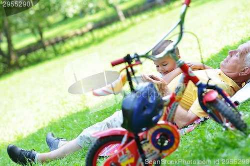 Image of grandfather and child in park using tablet