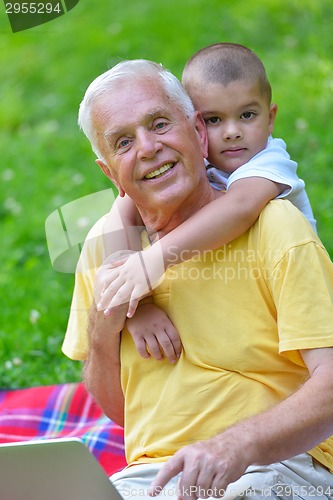 Image of grandfather and child using laptop