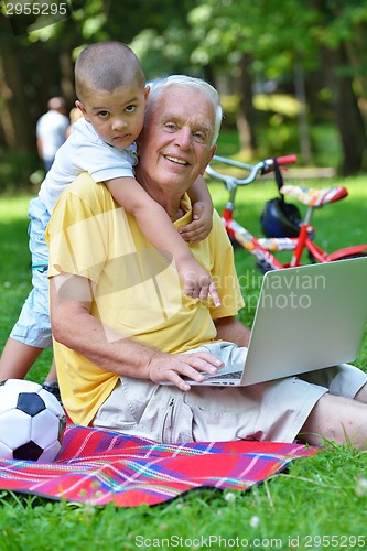 Image of grandfather and child using laptop