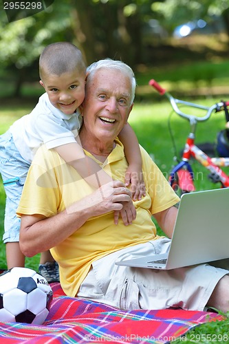 Image of grandfather and child using laptop