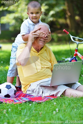 Image of grandfather and child using laptop
