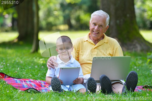 Image of grandfather and child using laptop