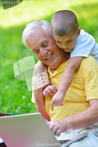 Image of grandfather and child using laptop