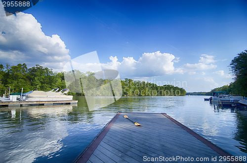 Image of boats at dock on a lake with blue sky