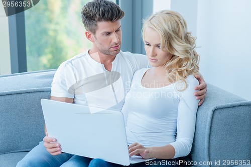 Image of Concerned young couple using a laptop computer