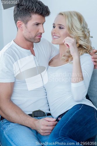 Image of Young couple cuddling on a sofa