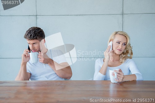Image of Couple both using their mobile phones