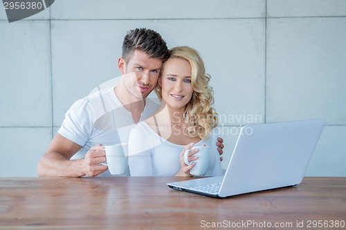 Image of Attractive couple having a mug of coffee