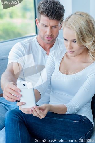Image of Couple reading a text message with consternation
