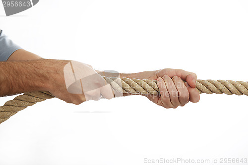 Image of Man in a blue shirt pulls a rope