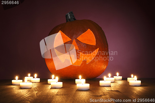Image of Pumpkin on a red background with candles