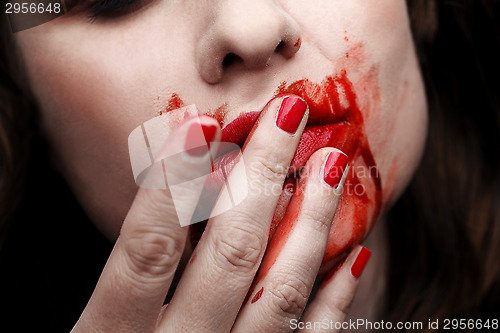 Image of Female vampire licking blood off