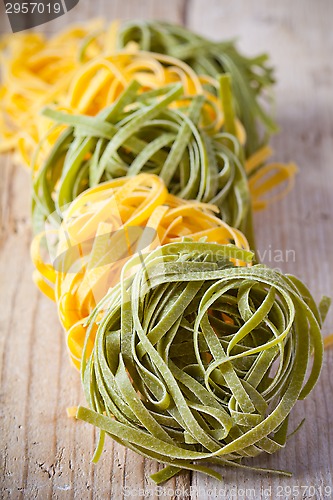 Image of yellow and green uncooked pasta tagliatelle 