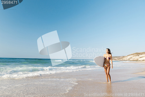 Image of Surfer girl with her surfboard