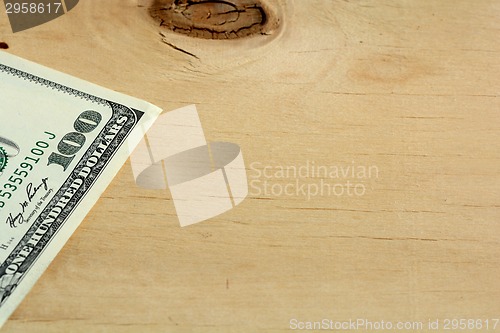 Image of One hundred dollars on wood background