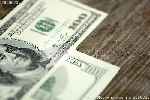 Image of Close-up of a $100 banknotes on wooden background