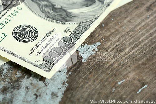 Image of Hundreds of US dollars on old wooden plank