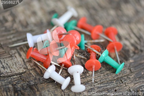 Image of old push pins set on old wooden background