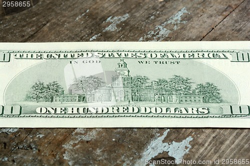 Image of Close-up of a $100 banknotes on wooden background