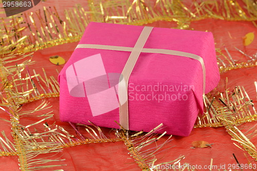 Image of A red gift with a white ribbon and a bow