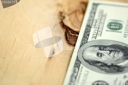 Image of American 100 U.S. dollars on wooden background