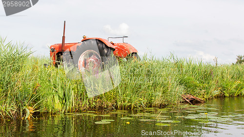 Image of Farmers pumping water with old tractor