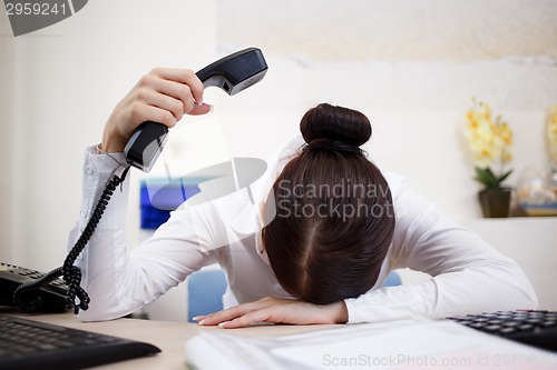 Image of Young attractive business woman with phone in hand