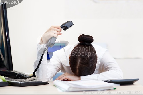 Image of Young attractive business woman with phone in hand