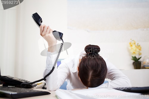 Image of Young attractive business woman with phone in hand