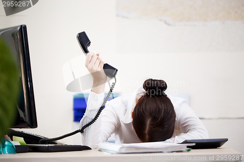 Image of Young attractive business woman with phone in hand