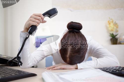 Image of Young attractive business woman with phone in hand