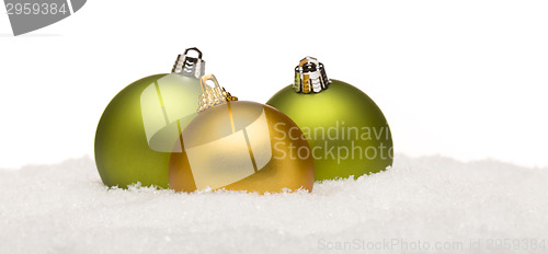 Image of Green and Yellow Christmas Ornaments on Snow Isolated on White