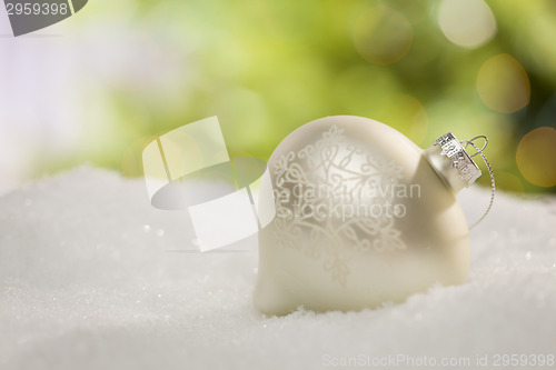 Image of White Christmas Ornament on Snow Over an Abstract Background