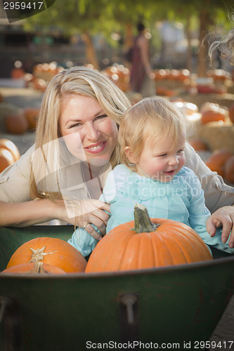 Image of Young Mother and Daughter Enjoys the Pumpkin Patch