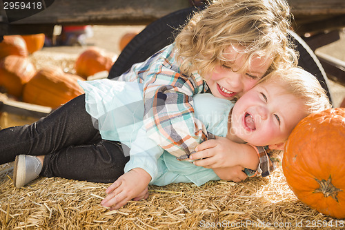 Image of Little Boy Playing with His Baby Sister at Pumpkin Patch