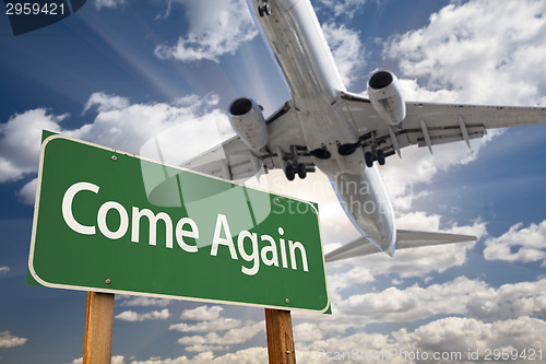 Image of Come Again Green Road Sign and Airplane Above
